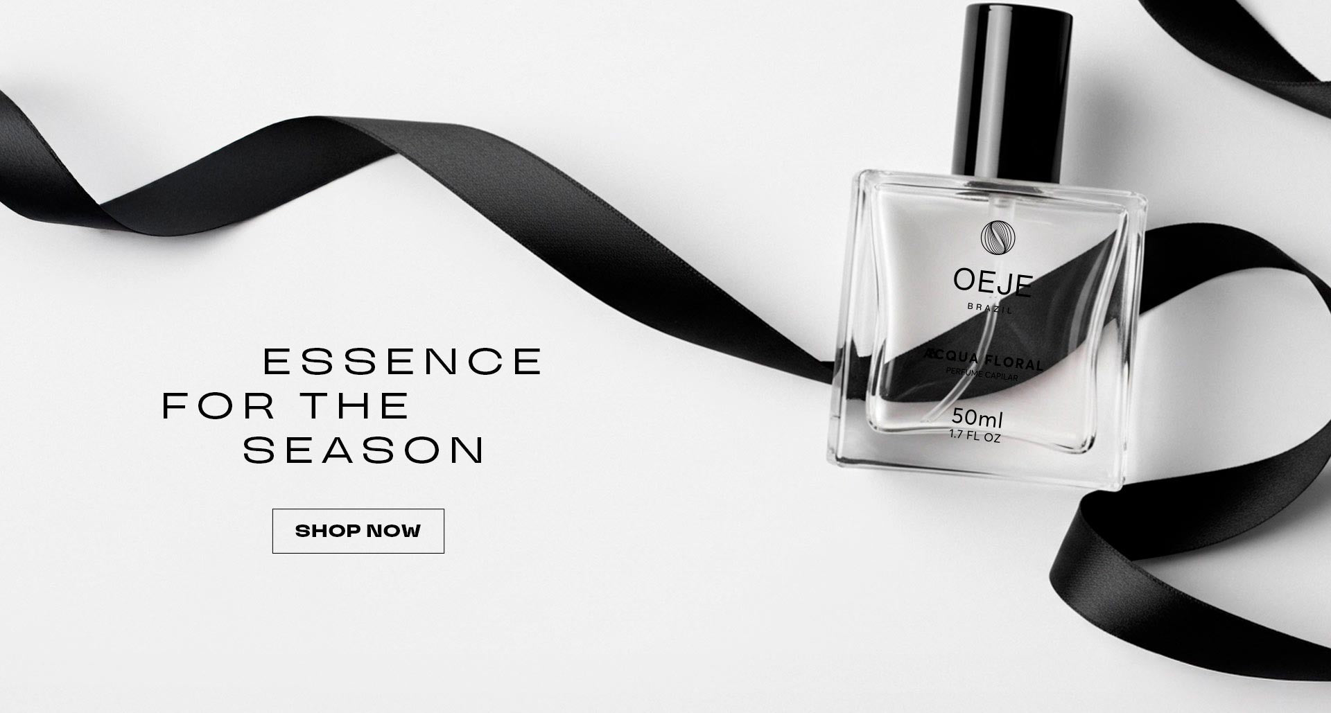 Frasco de perfume OEJE Acqua Floral 50ml com fita preta sobre fundo branco. Texto: Essence for the Season.